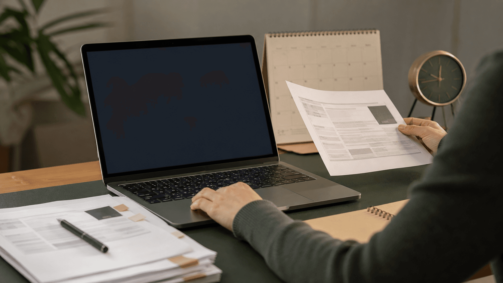 Applicant checking a current PhD listing on a laptop beside source notes.